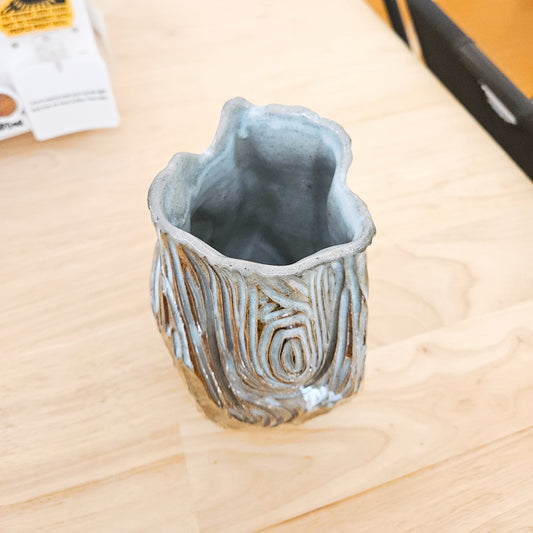 Ceramic vase with textured surface on a wooden table