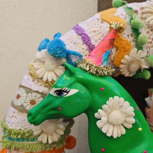 Colorful horse figurine with decorative elements on a plain background