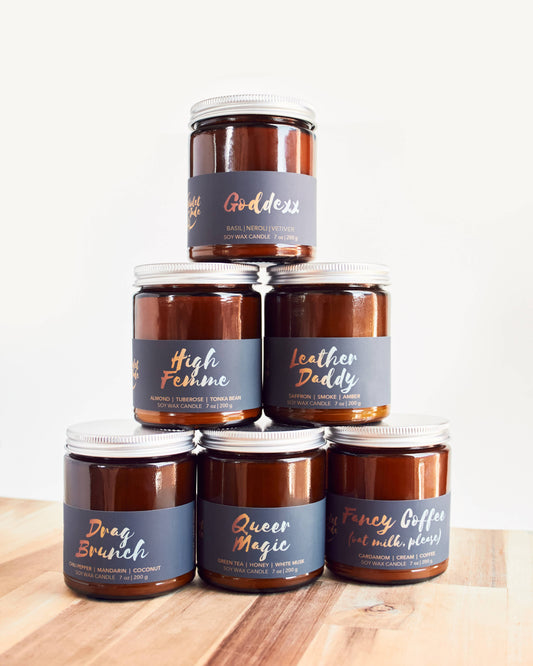 Stack of candles with labeled containers on a wooden surface