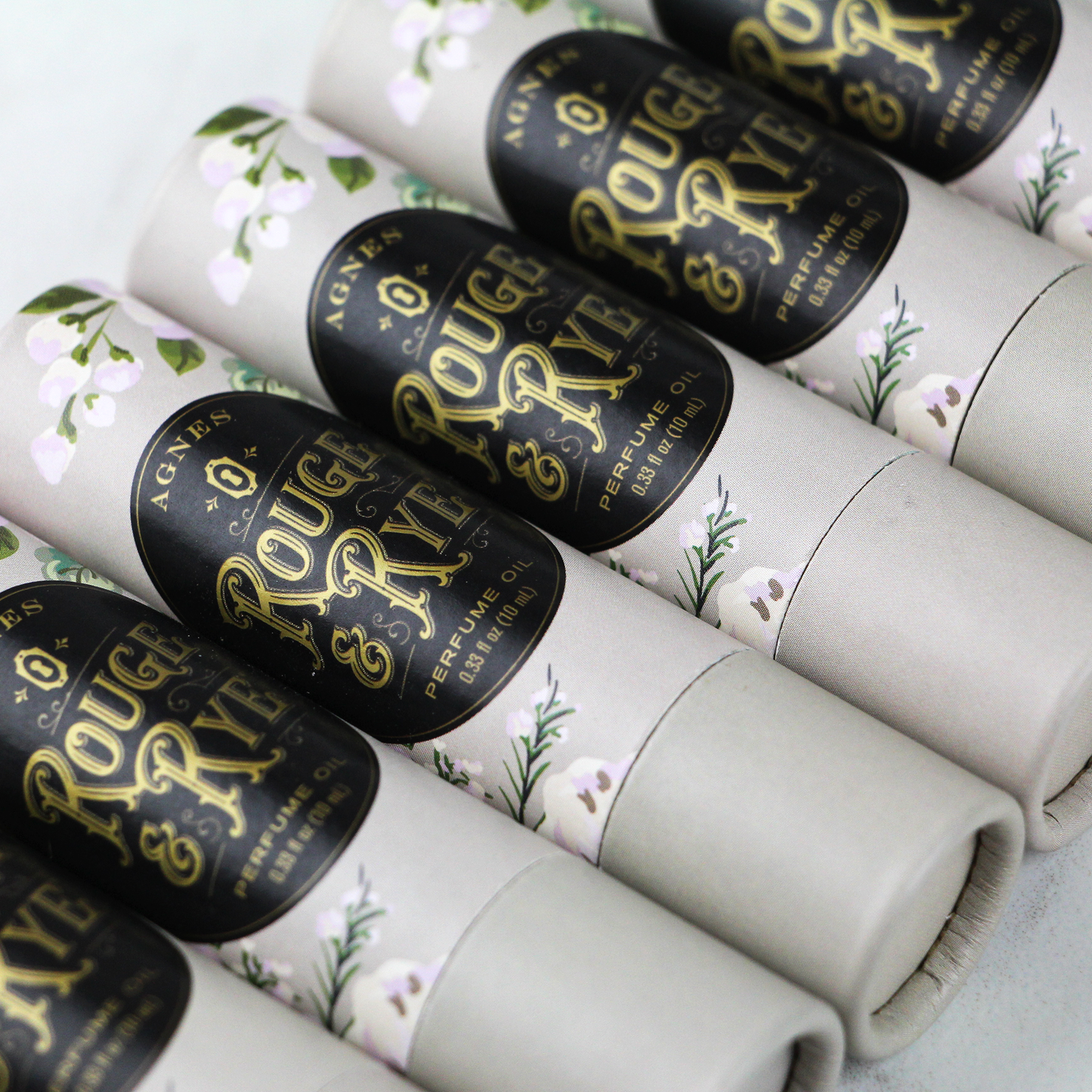 Rolls of paper with 'Rouge & Rye' branding on a floral background