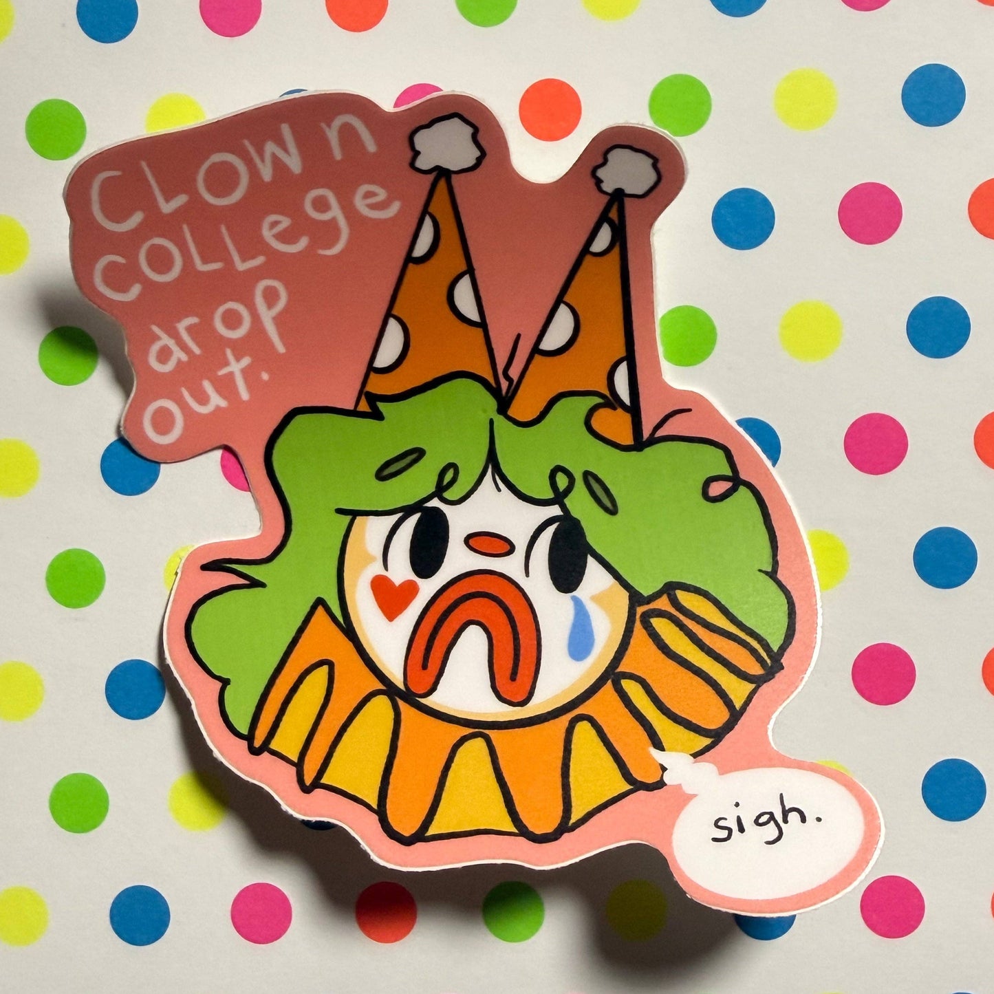 A die-cut sticker featuring a distressed, crying clown illustration with the text 'Clown college drop out.' and 'sigh.