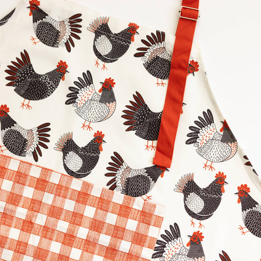 Patterned fabric with chicken design and checkered tablecloth on a white background