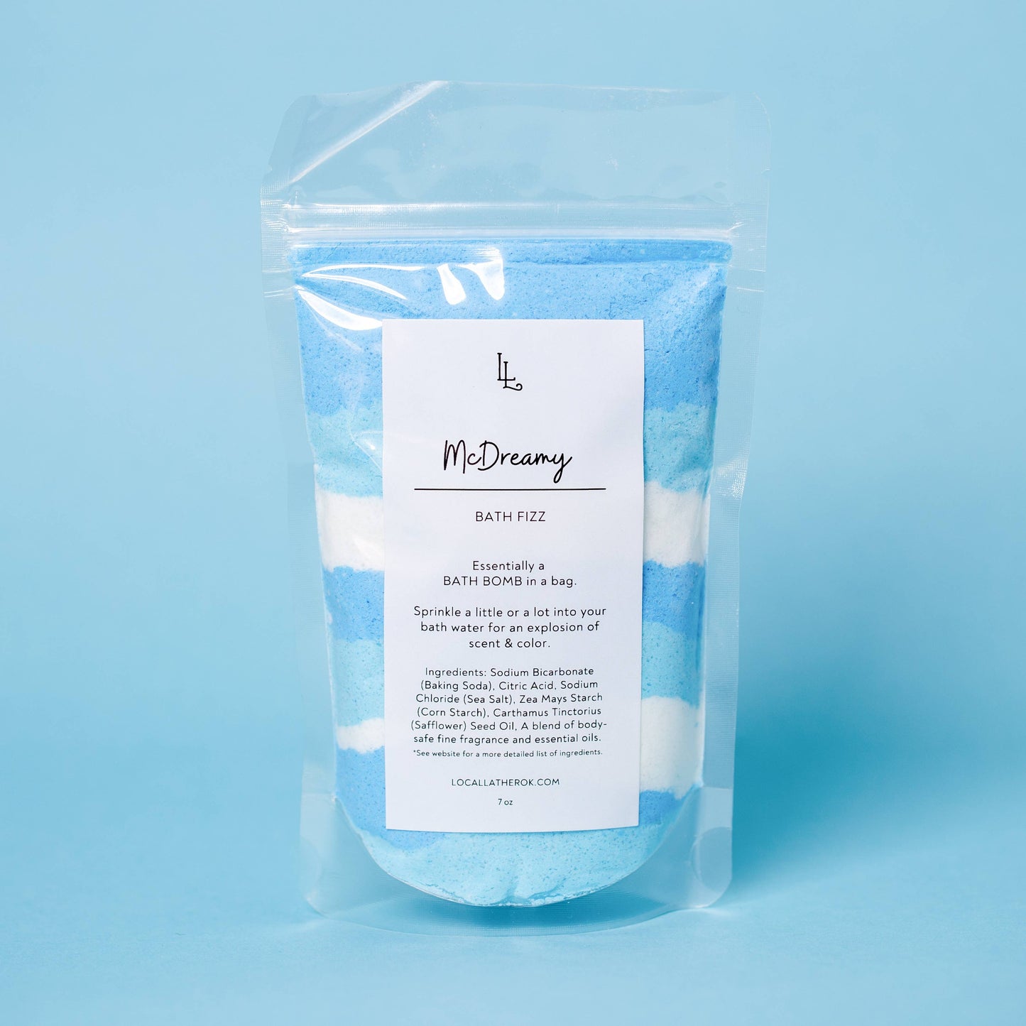 Packaged bath fizz product with a label on a blue background