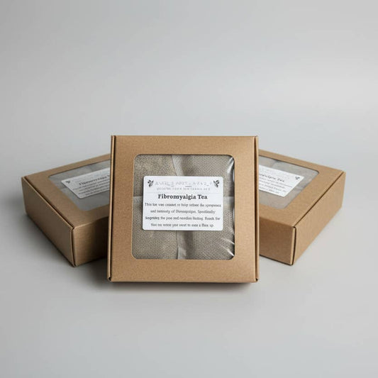 Three small kraft paper boxes with clear front windows displaying loose-leaf herbal tea, arranged on a light gray background.