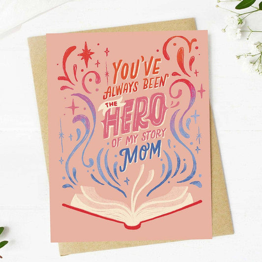 Greeting card with 'You've always been the hero of my story Mom' text on a pink background