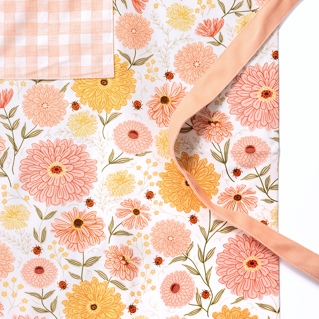 Floral-patterned mat with a person's hand holding it, featuring the brand 'Ginger.'