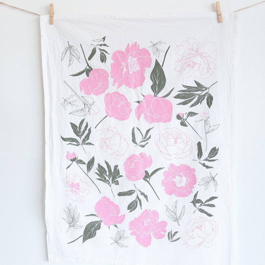 Floral patterned towel hanging on a line against a white background