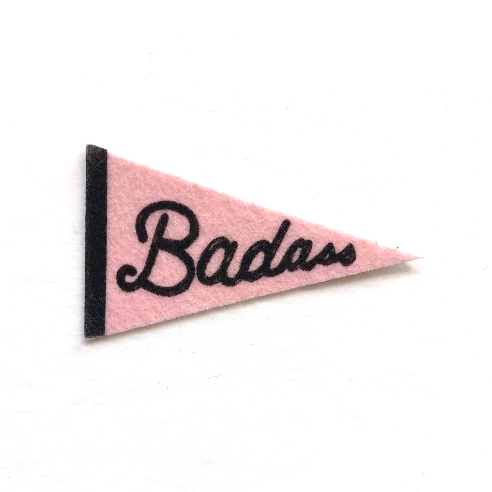 Pink triangle-shaped pennant with 'Badass' text on a white background