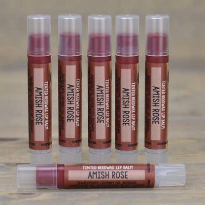 Set of Amish Rose lip balm tubes on a wooden surface