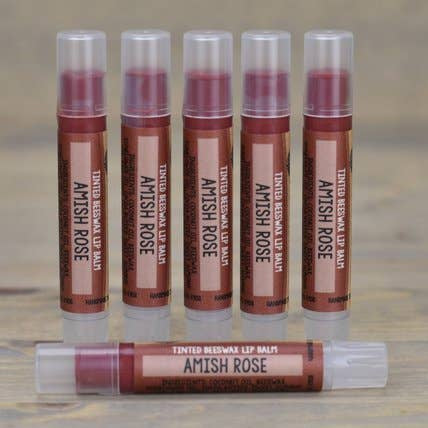 Set of Amish Rose lip balm tubes on a wooden surface