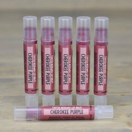 Set of lip balm tubes labeled 'Cherokee Purple' on a wooden surface