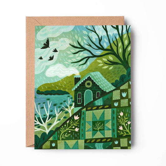 A square art print or card featuring a stylized landscape illustration in shades of green, teal, and brown, shown with a kraft paper envelope behind it on a white background.