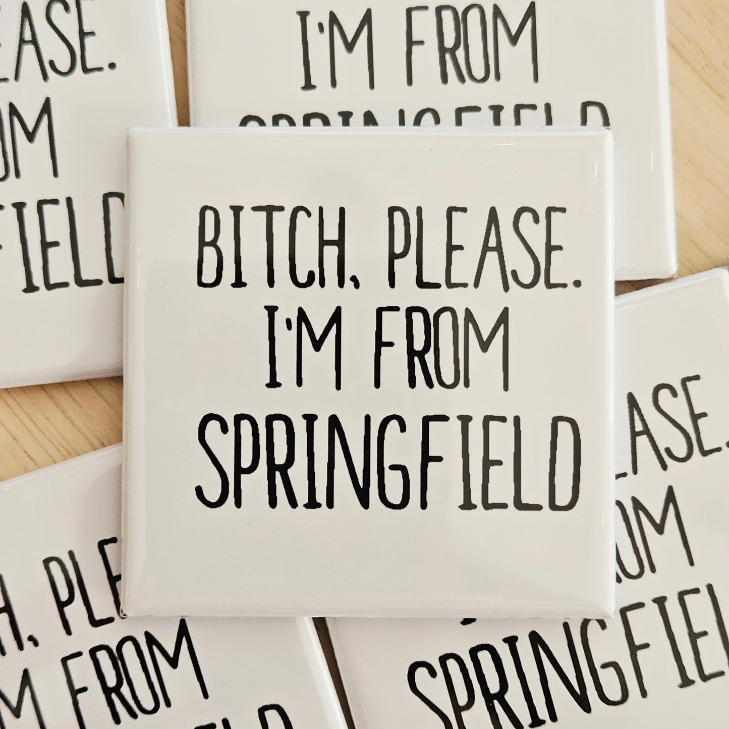 Coaster with 'Bitch, Please. I'm from Springfield' text on a wooden surface.