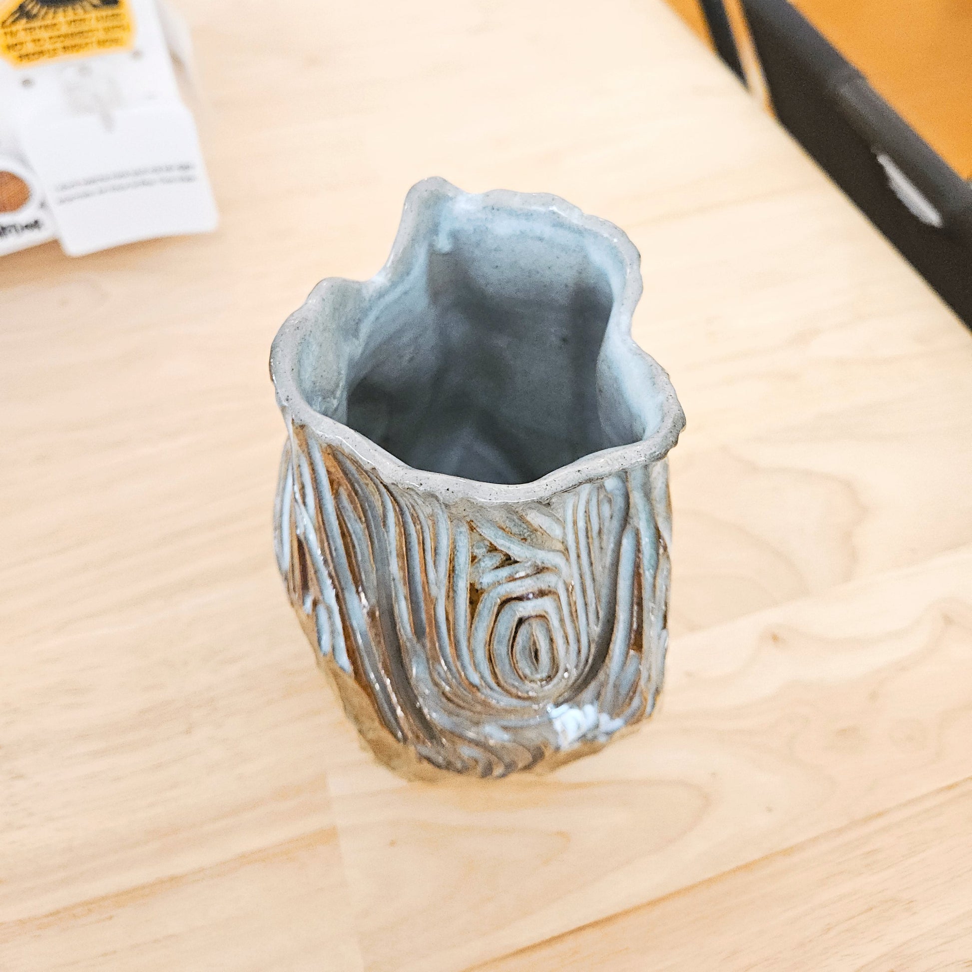 Ceramic vase with textured surface on a wooden table