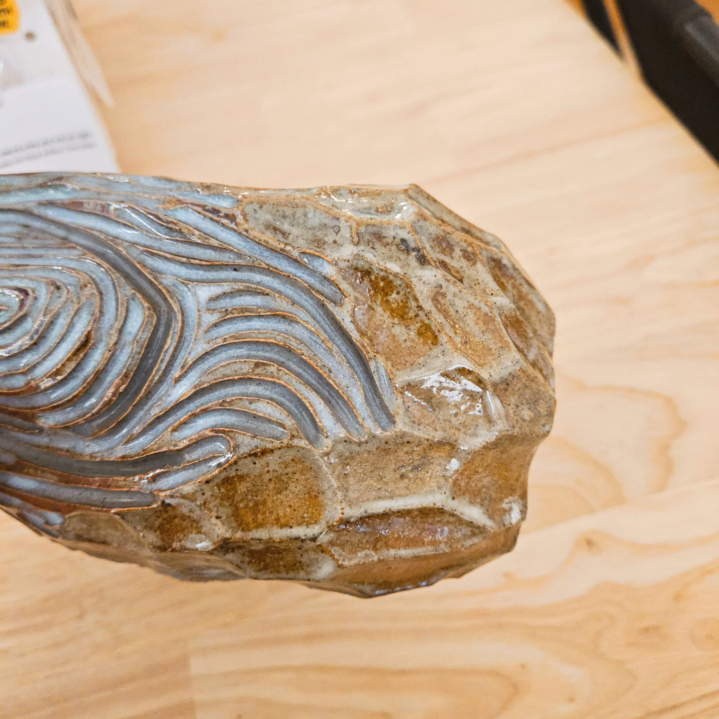 Decorative stone with wavy patterns on a wooden surface