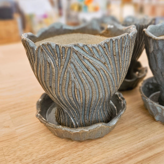 Decorative ceramic pots with textured design on a wooden surface