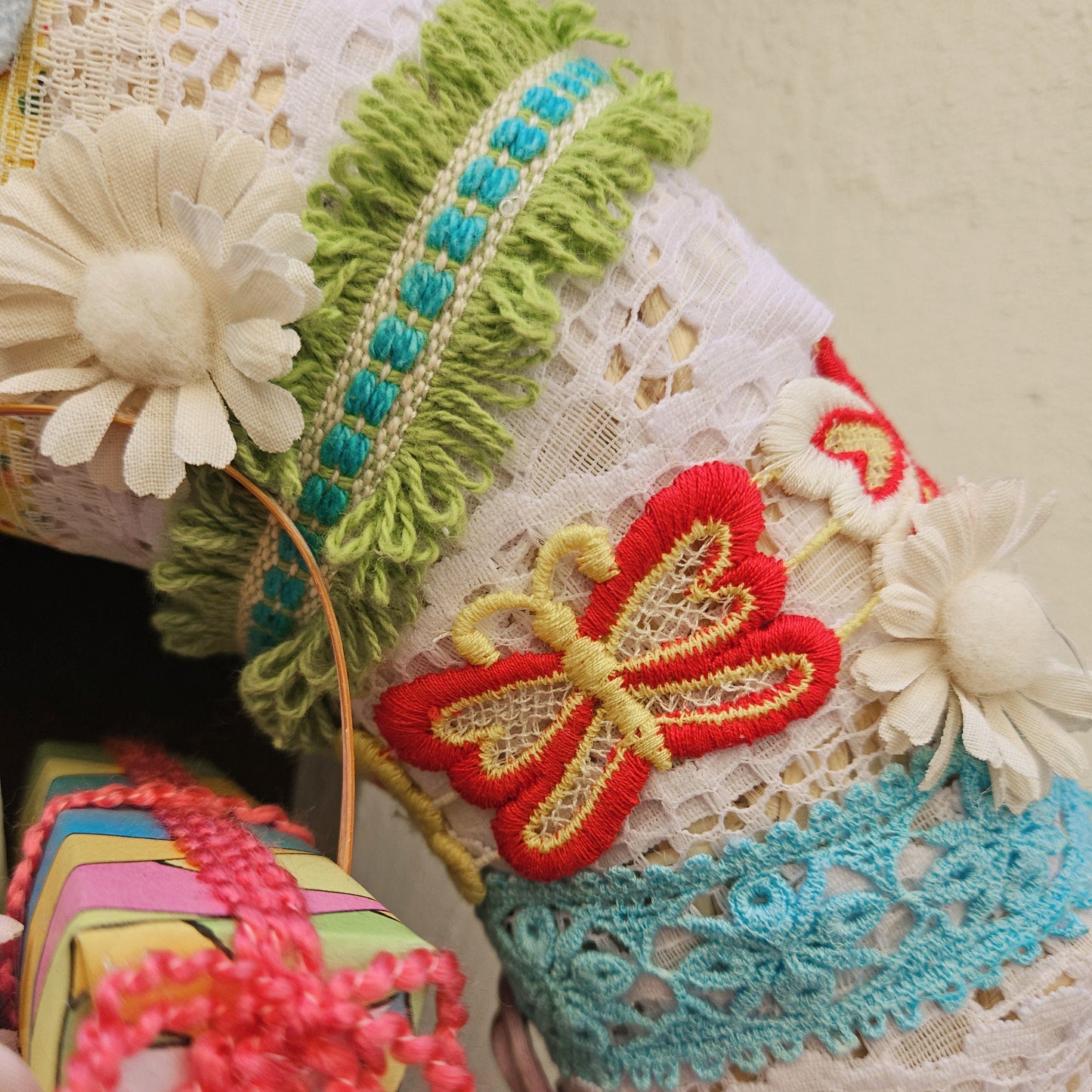 Decorative  wreath detail with flowers and lace details on a neutral bakcground