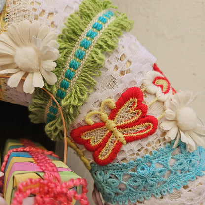 Decorative  wreath detail with flowers and lace details on a neutral bakcground