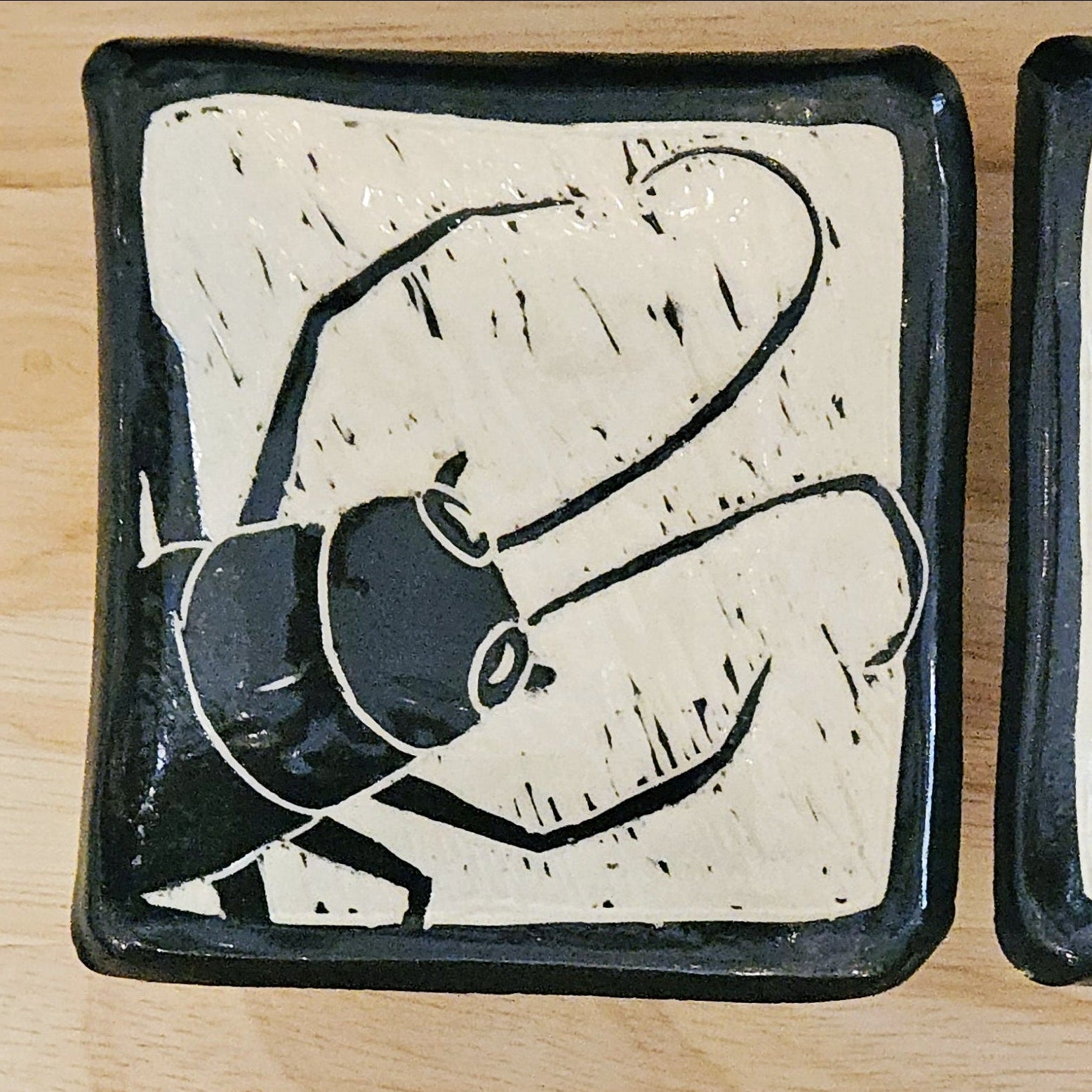 Set of three ceramic trays with abstract black designs on a wooden surface