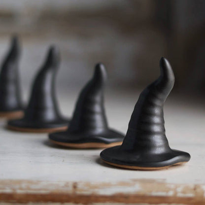 Black witch hats on a wooden surface with a blurred background