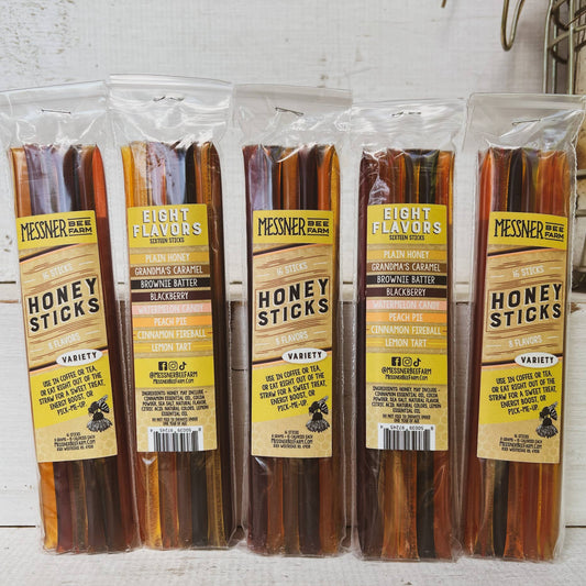 Packaged honey sticks with Messner Bee Farm labels on a white background