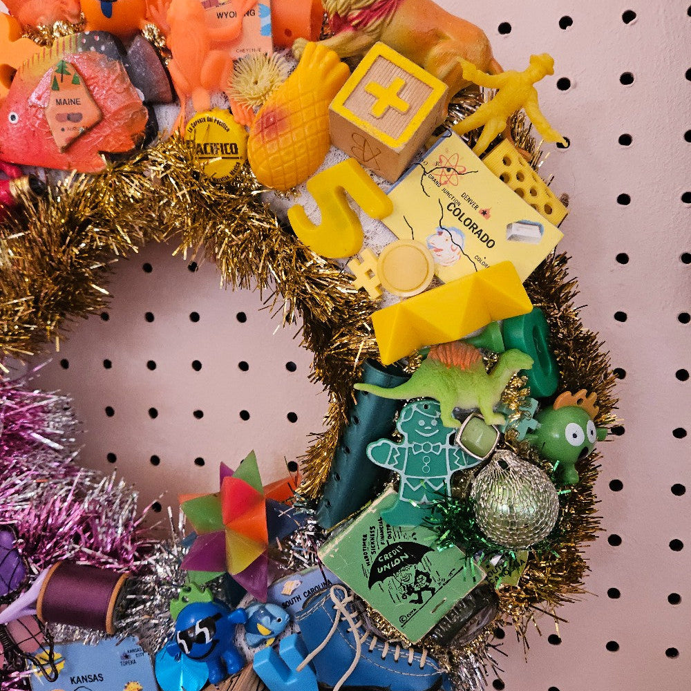 Decorative wreath with colorful items on a pegboard background