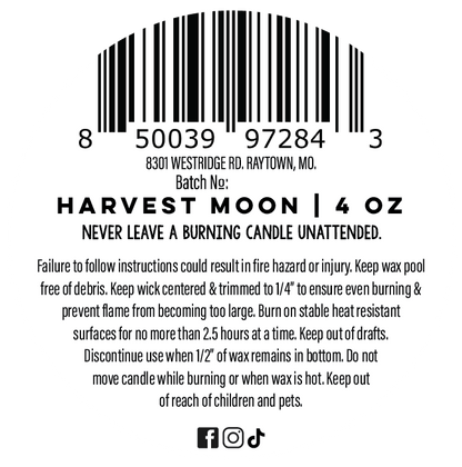 A black printed candle label on a white background with a barcode, product name 'Harvest Moon | 4 oz', batch number, safety instructions, and small social media icons at the bottom.