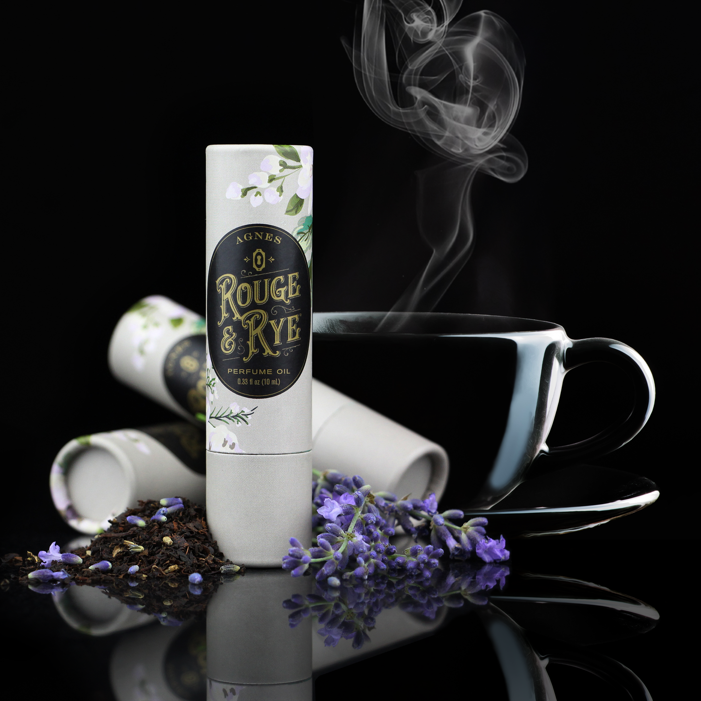 Rouge & Rye product with a cup of tea and lavender on a reflective surface