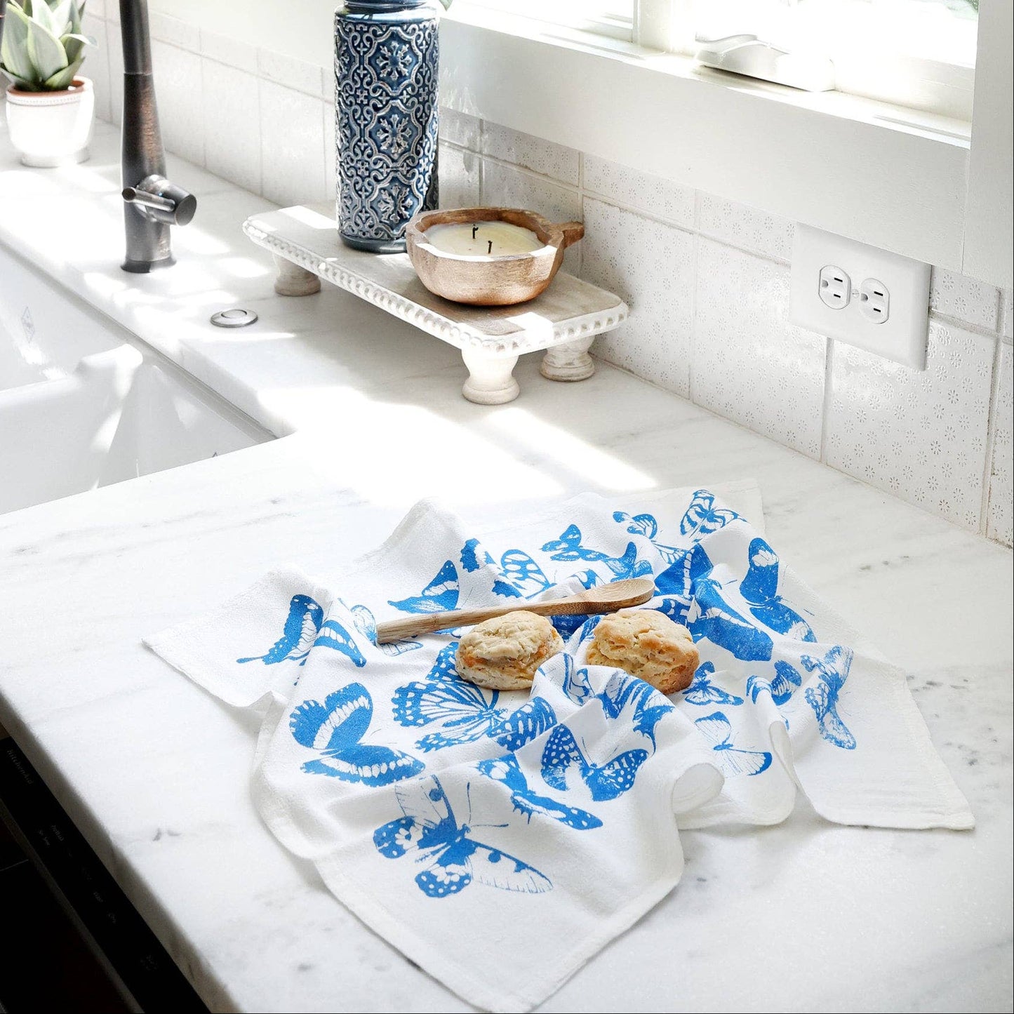 Kitchen counter with a blue and white towel, sink, and window view