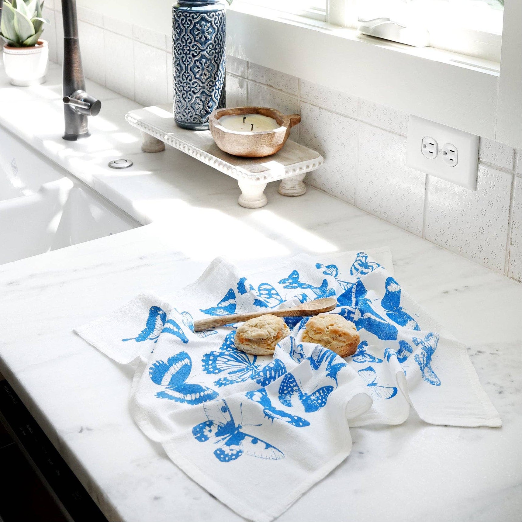 Kitchen counter with a blue and white towel, sink, and window view