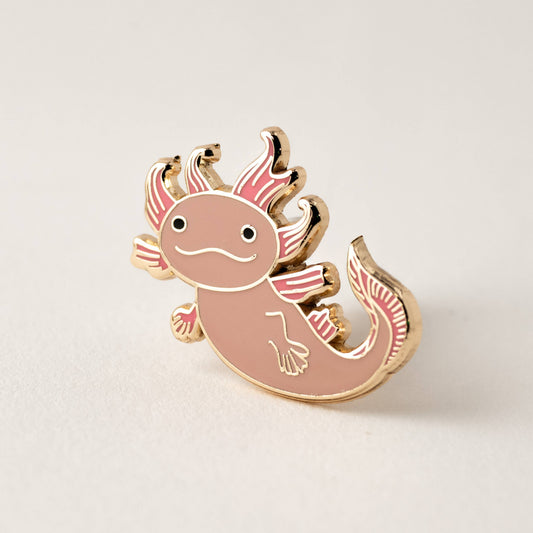 Pin with pink axolotl design on a light beige background