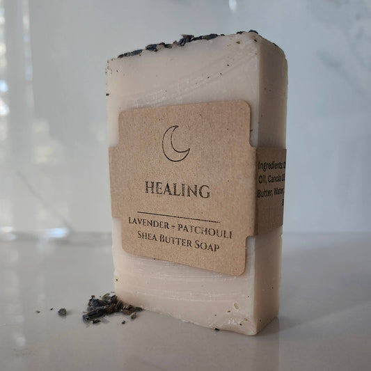 Shea butter soap bar with a label on a reflective surface