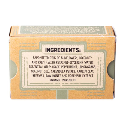A square kraft paper box with a large white label detailing the ingredients, including saponified oils of sunflower, coconut, and palm, water, and essential oils like sage, peppermint, and lemongrass. The box is photographed on a clean white background.