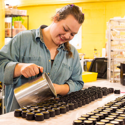 Person working with containers on a table in a yellow-walled room