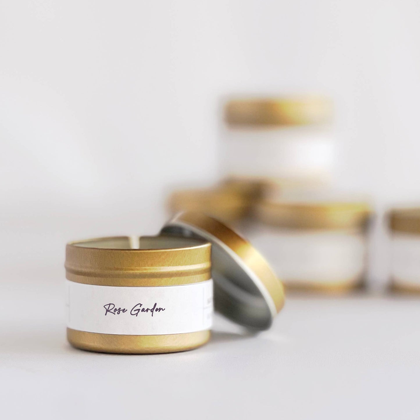 Candle with gold lid and white label on a light background
