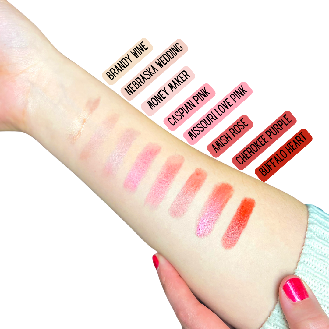 Lipstick swatches on a person's arm with color names above each swatch.