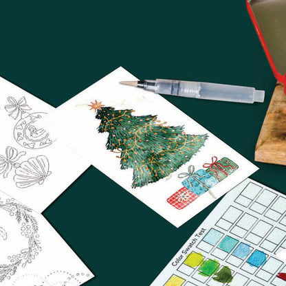A watercolor painting and coloring kit displayed on a dark green background, featuring a red metal paint palette, a clear water brush, and several coloring pages with Christmas-themed designs like a tree, wreath, and ornaments.