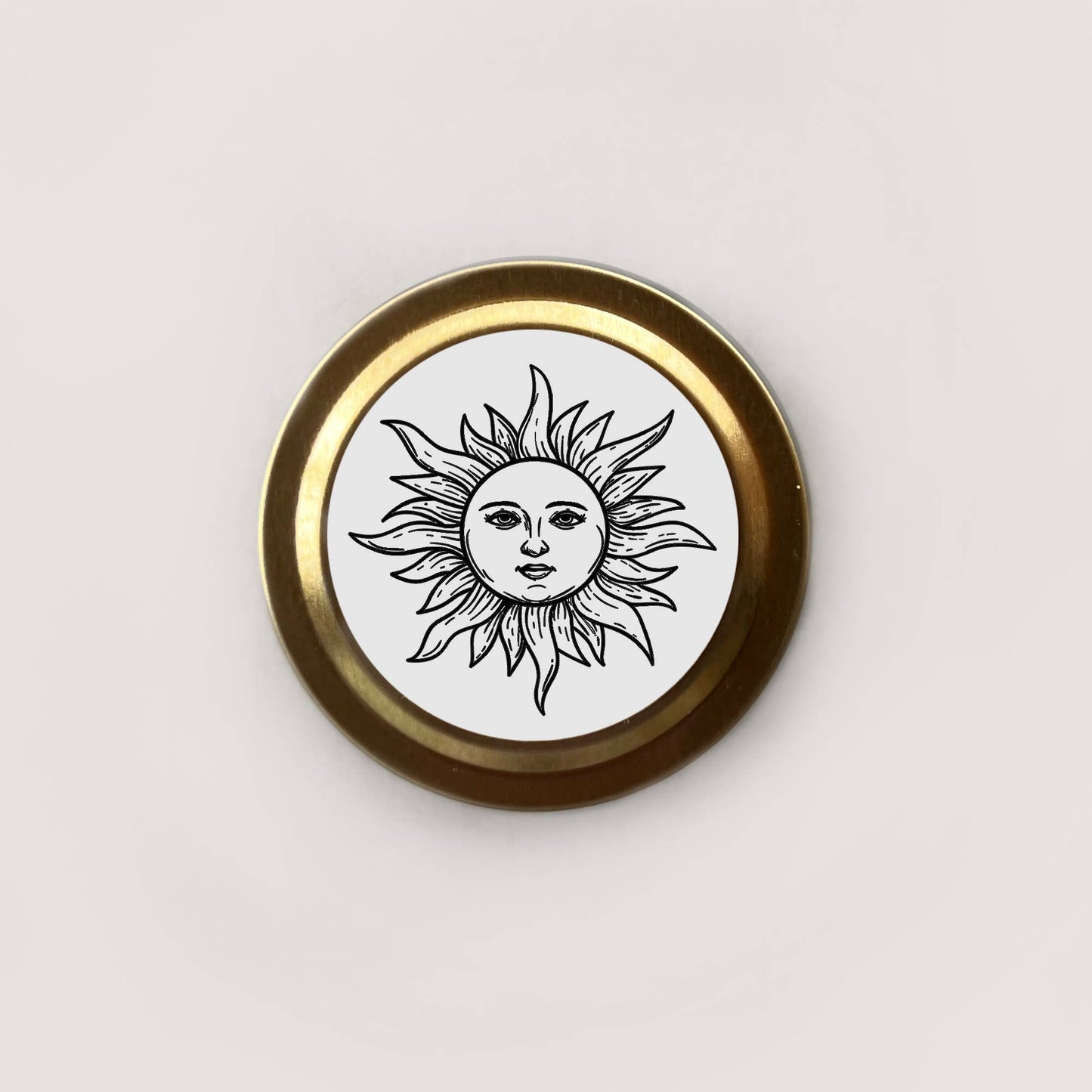 Round badge with sun design and gold border on a white background