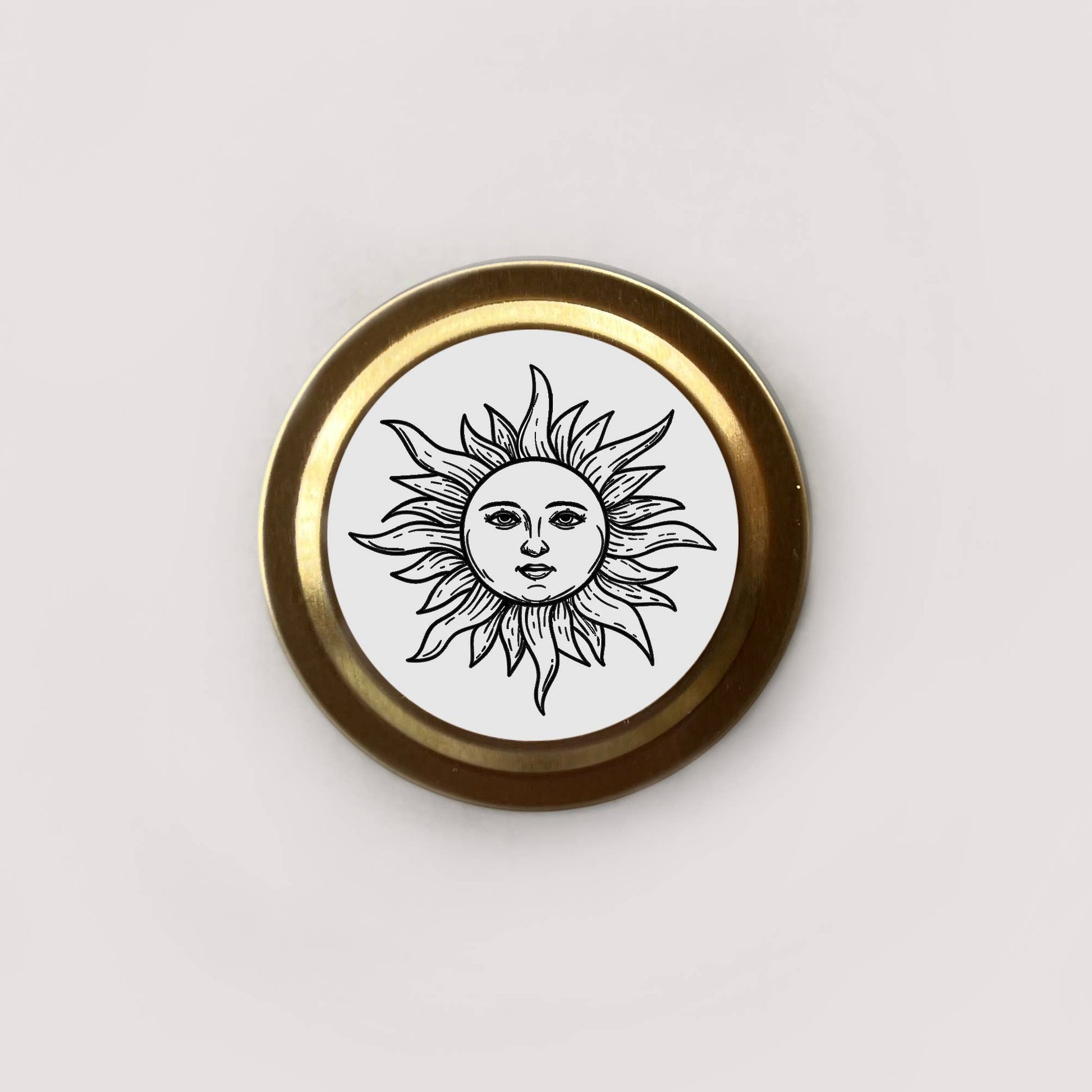 Round badge with sun design and gold border on a white background
