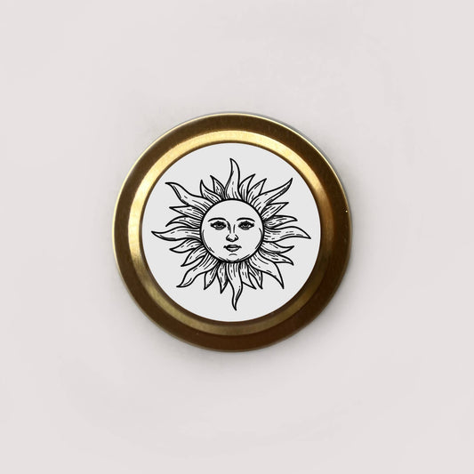 Round badge with sun design and gold border on a white background