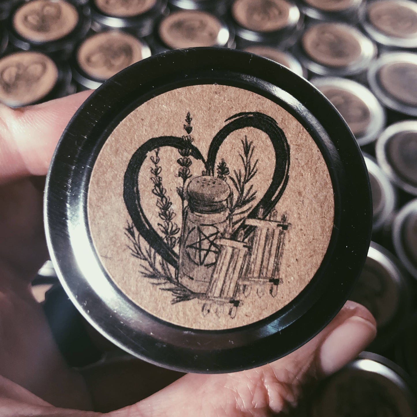 Close-up of a decorative button with intricate design held by a hand against a background of similar buttons.