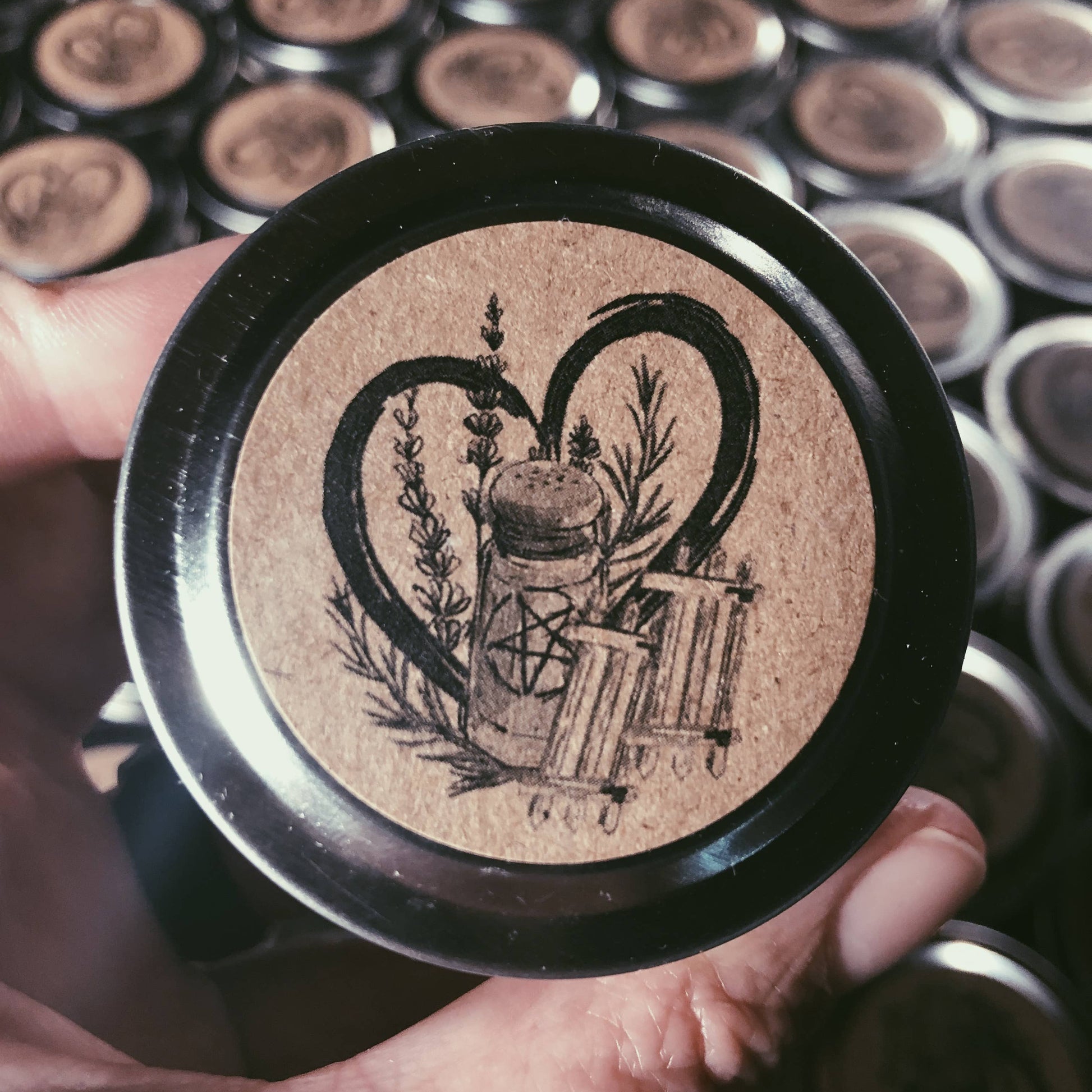 Close-up of a decorative button with intricate design held by a hand against a background of similar buttons.
