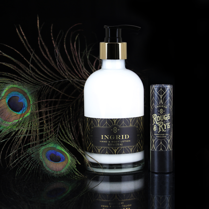 A hand and body lotion bottle and a lip balm tube from the brand INGRID, styled with decorative peacock feathers on a reflective black background.