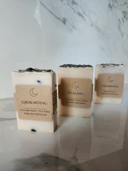 Three bars of soap with labels on a marble surface