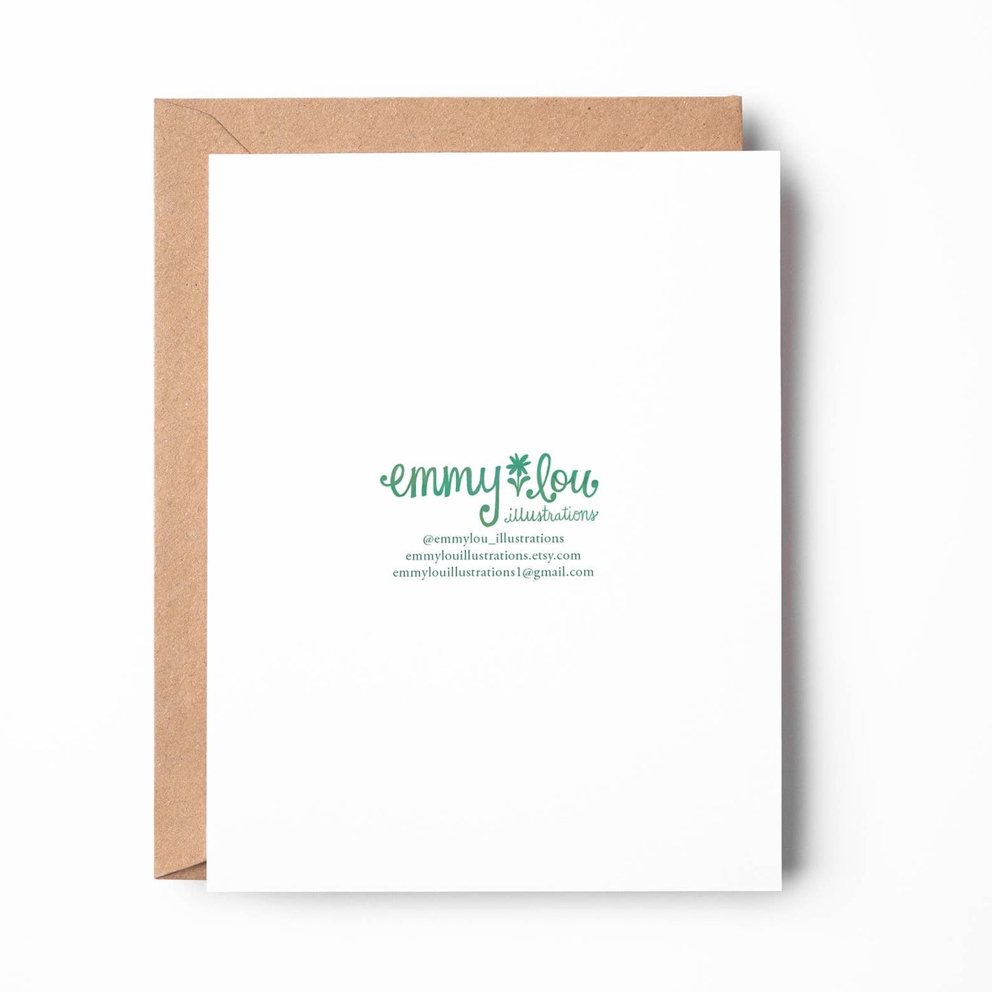 A white greeting card with elegant green script reading 'emmylou' and smaller text below, shown with a kraft brown envelope on a clean white background.