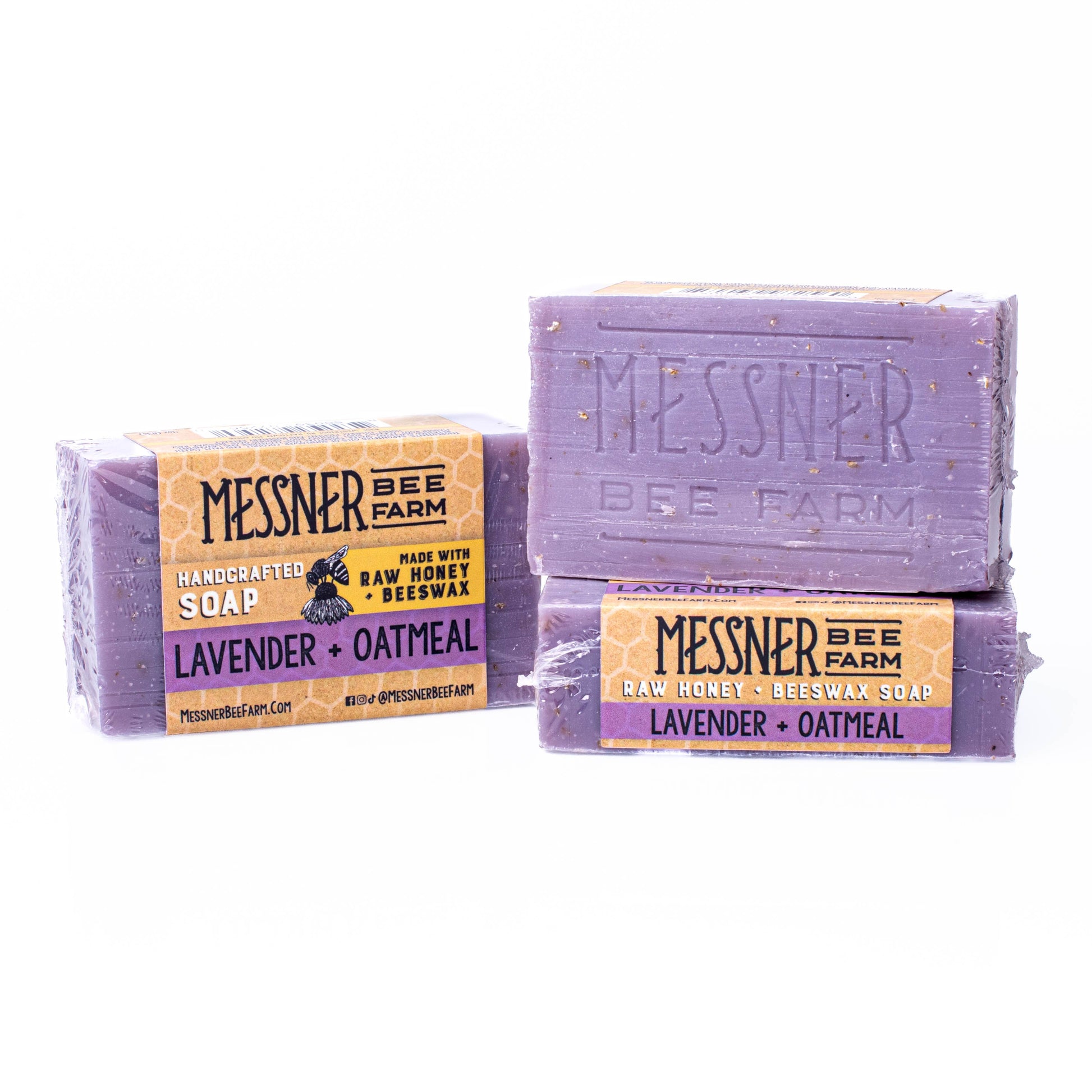Two bars of Messner Bee Farm lavender and oatmeal soap on a white background