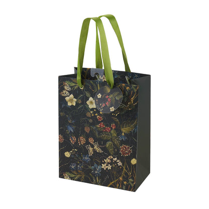 Floral-patterned gift bag with green handles on a white background