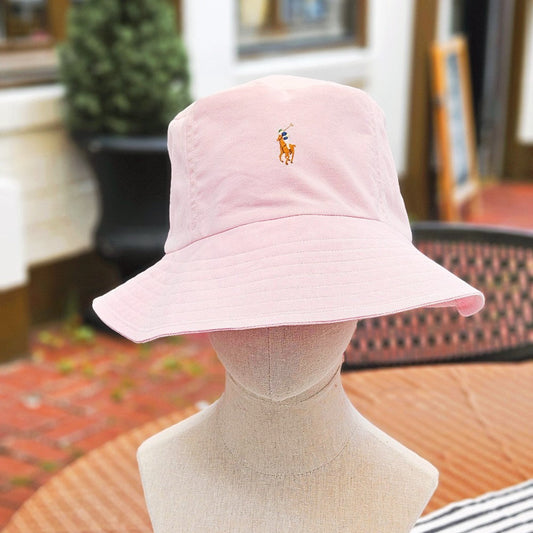 Pink Bucket Hat on a manneqin head on an outdoor table. 