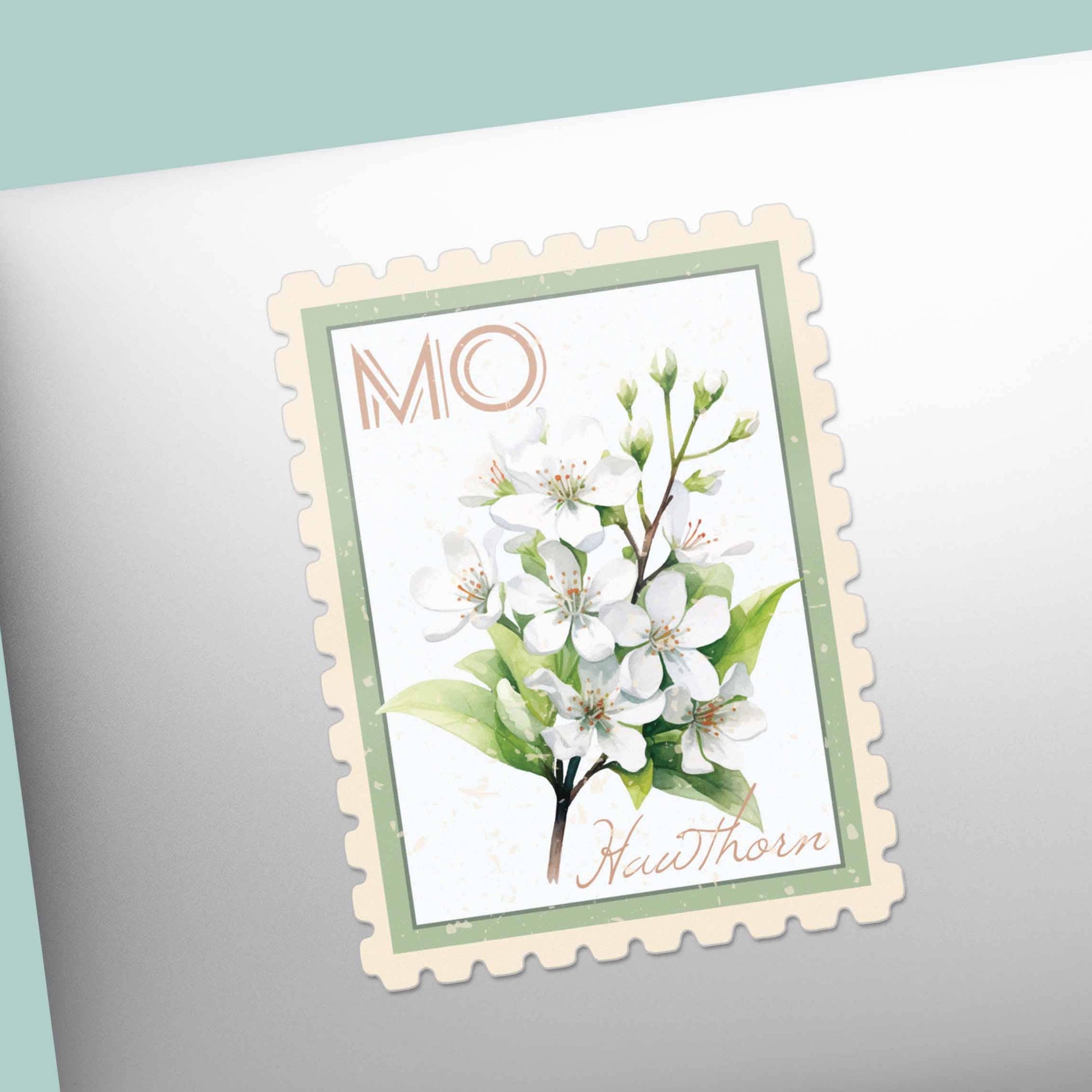 Decorative stamp with white flowers and green leaves on a laptop
