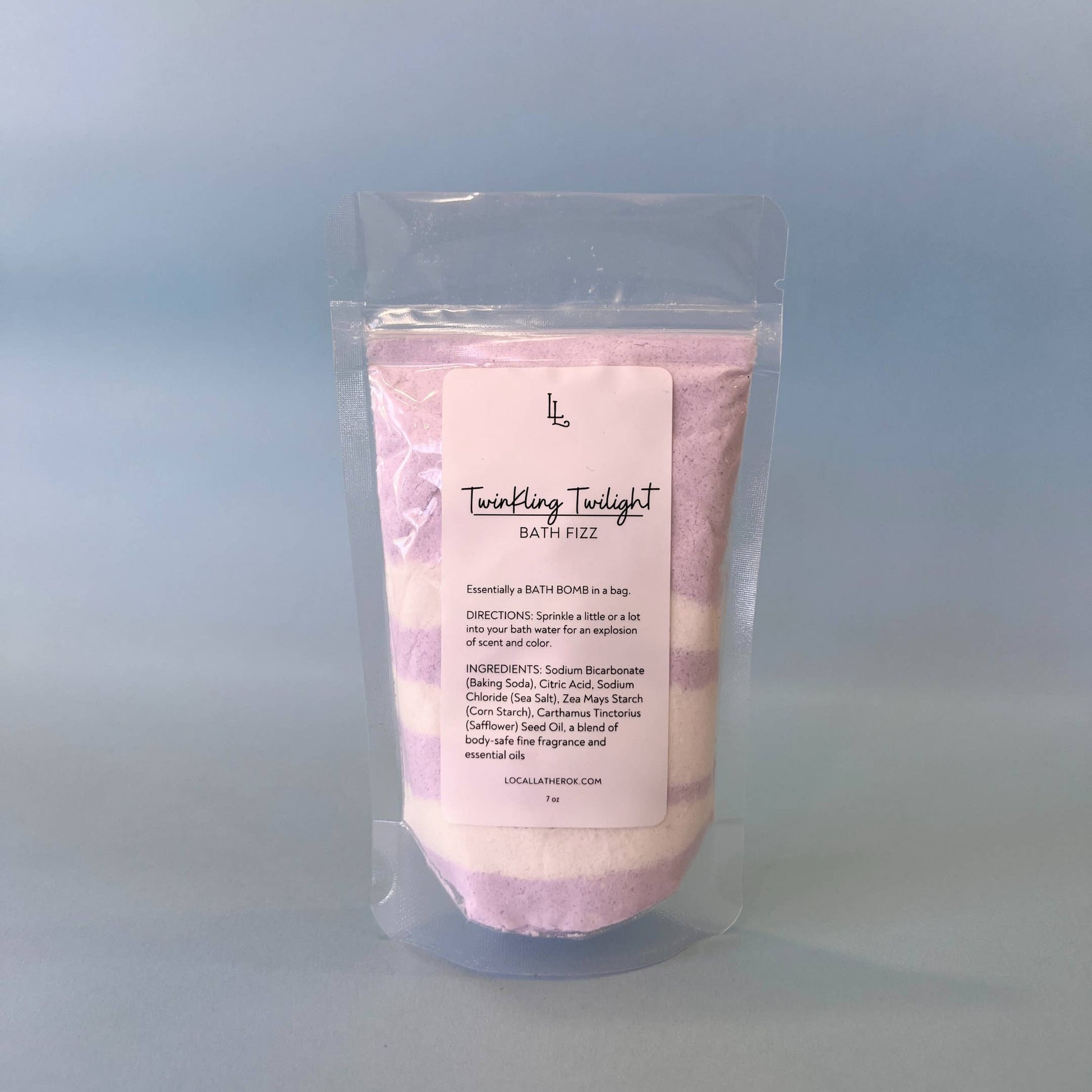 Pink bath fizz package with a label on a light blue background